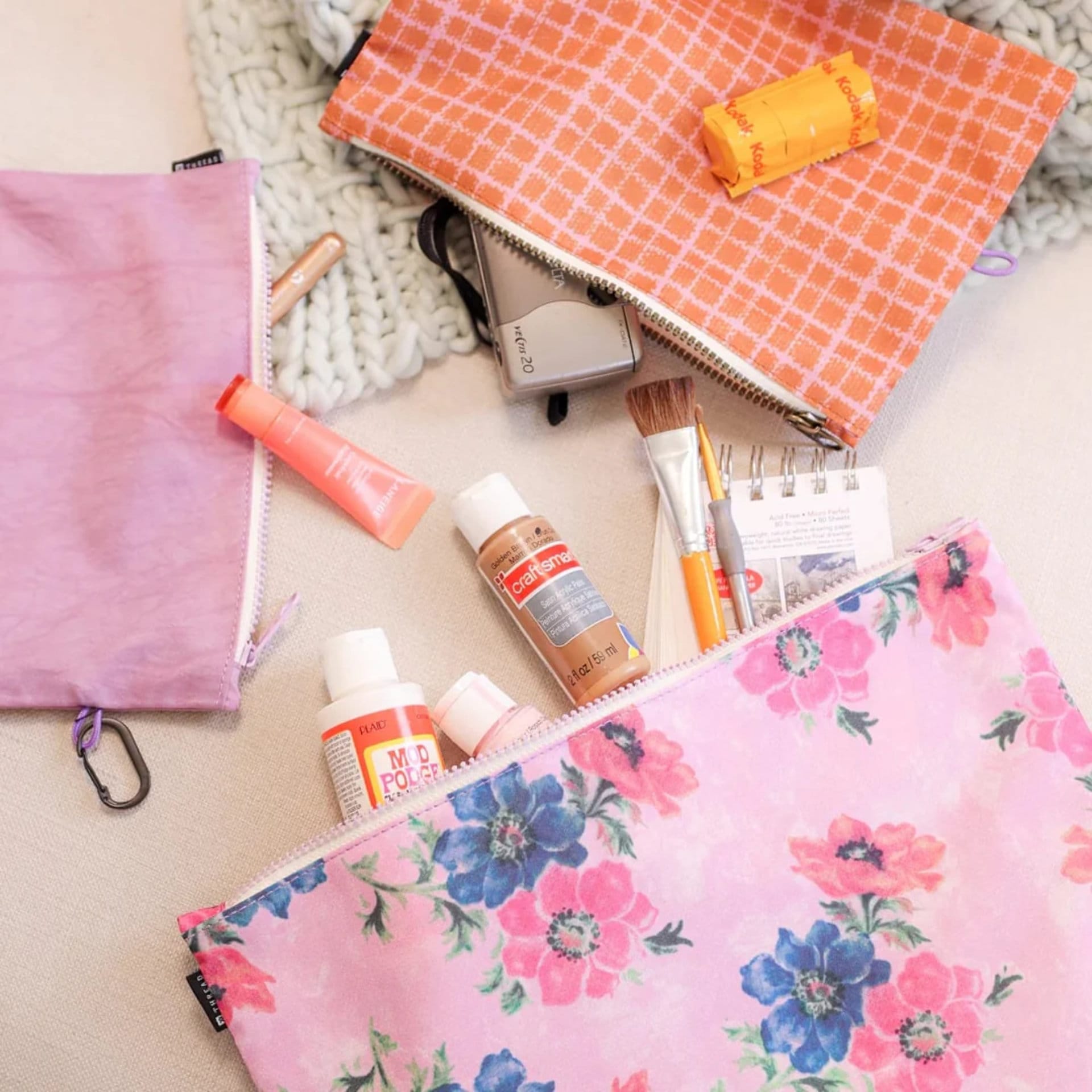 Handmade floral, pink, and coral pouches filled with art and beauty supplies